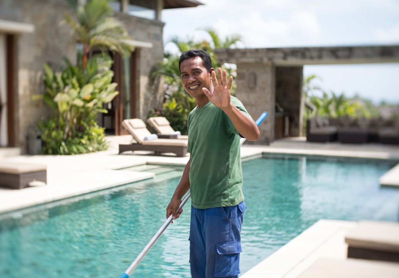 Pool technician cleaning a villa pool